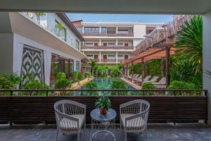 balcón con mesa, sillas y piscina en Siemreap Vasinh Residence, en Siem Reap