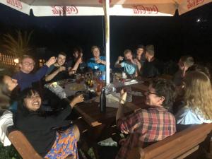 a group of people sitting at a table at night at Guest House Rrashkadoli in Theth