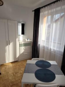 a small kitchen with a table and two stools at APARTAMENTY i Pokoje Gościnne ZOSIA in Darłówko