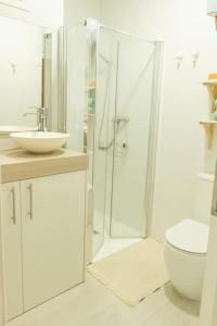 a bathroom with a shower and a toilet and a sink at Lindamar Canteras Beach House in Las Palmas de Gran Canaria