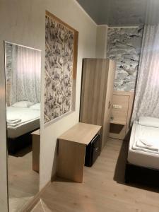 Pokój z 2 łóżkami, stołem i lustrem w obiekcie Hotel My Rose w mieście Batumi