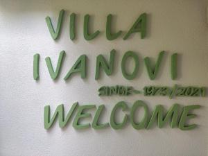 a green sign on a wall that reads virgin wan awine welcome at Villa Ivanovi in Ohrid