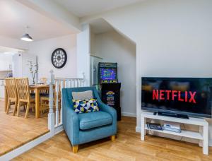 a living room with a tv and a blue chair at Relaxing Retreat Perfect For Longer Stays in Southampton
