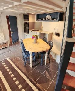 uma cozinha com mesa e cadeiras num quarto em Mill Cottage Garden Annexe em Newton Abbot