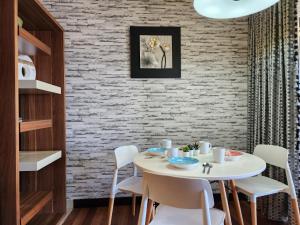 una sala da pranzo con un tavolo bianco e sedie bianche di Lagoon View With Balcony 1-5pax Sunway Resort Netflix a Petaling Jaya