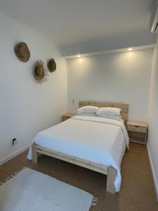 ein weißes Schlafzimmer mit einem großen Bett mit weißer Bettwäsche in der Unterkunft Estúdio Albergaria in Albergaria-a-Velha