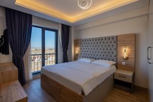 a bedroom with a large bed and a large window at Afyon Regulus Thermal Apart Hotel & Villas in Gazligol +22 photos