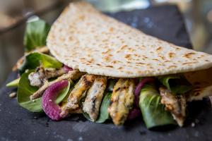 un sandwich avec de la viande et des légumes et une tortilla dans l'établissement B&B I TRE GATTI, à Pesaro