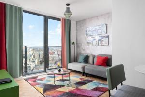 uma sala de estar com um sofá e uma grande janela em Church Street by Supercity Aparthotels em Manchester