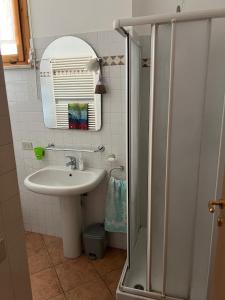 La salle de bains est pourvue d'un lavabo, d'un miroir et d'une douche. dans l'établissement B&B I TRE GATTI, à Pesaro