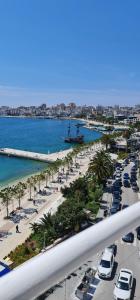 a view of a beach with cars parked on the street at Summer Breeze Apartment Saranda in Sarandë