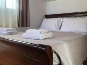 a bedroom with a bed with towels on it at Milos Apartments in Himare