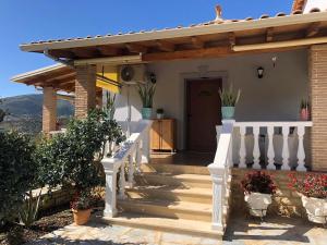 a house with a staircase leading to the front door at Milos Apartments in Himare