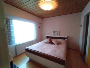 una camera da letto con un letto e una luce sul soffitto di Punkaharju Savonlinna, perheasunto, Family home a Savonlinna