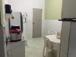 a small kitchen with a table and a refrigerator at Espaço Verde in Vitória