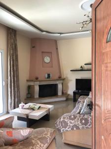 un soggiorno con divano e camino di Milos Apartments a Himare