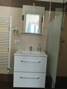 La salle de bains est pourvue d'un lavabo blanc et d'un miroir. dans l'établissement Elis...land..., à Torre Canne