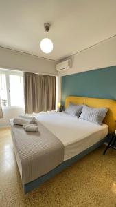 a bedroom with a large bed with a yellow headboard at Crown Syntagma Apartment in Athens