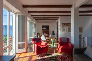 a living room with two red chairs and a table at Cadebei in Oggebbio