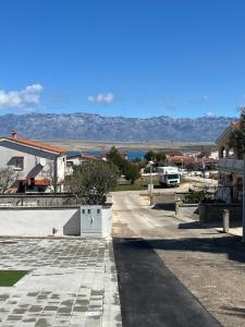 une rue dans une ville avec des montagnes en arrière-plan dans l'établissement Apartment Irene, à Vir