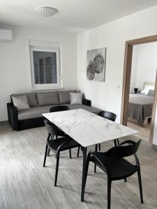 un salon avec une table, des chaises et un canapé dans l'établissement Apartment Irene, à Vir