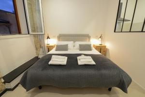 a bedroom with a large bed with two towels on it at Emperador in Alghero