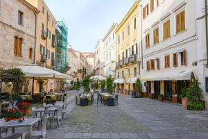 an empty street with tables and chairs and buildings at Emperador in Alghero