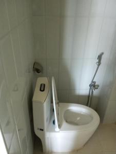 a white toilet in a white tiled bathroom at Hotel Sarangkot in Pokhara