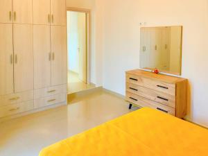 a bedroom with a bed and a dresser and a mirror at Lefkada house with private yard parking 2 in Nydri