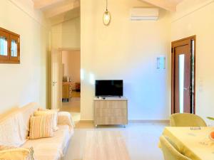 a living room with a couch and a tv at Lefkada house with private yard parking 2 in Nydri