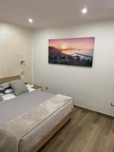 um quarto com uma cama e um quadro na parede em MareMonti apartments em Castellammare di Stabia