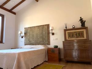 a bedroom with a bed and a wooden dresser at Casa do Palheiro, Bade, Cerdal. in Bade