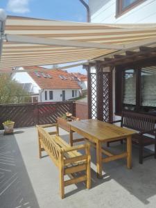 een houten pergola met een houten tafel en banken bij Schöne Ferienwohnung mit Balkon und Terrasse in ruhiger Lage in Helsa