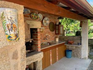 a kitchen with a brick oven and a sink at Casa do Palheiro, Bade, Cerdal. in Bade