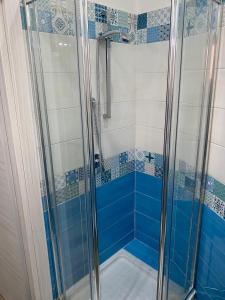 um chuveiro com azulejos azuis e brancos na casa de banho em MareMonti apartments em Castellammare di Stabia