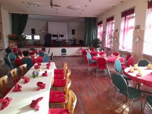 a room filled with tables and chairs with red napkins at Gasthaus Zur Rose in Malsch