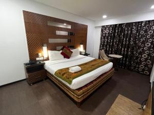 a bedroom with a large bed in a room at Ramee Guestline Hotel Bangalore in Attibele