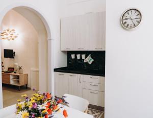 een keuken met witte kasten en een klok aan de muur bij Mare Adesso in Polignano a Mare