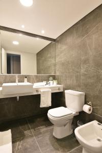 a bathroom with a toilet and a sink and a mirror at Exclusivo apartamento en Punta Carretas con Garaje in Montevideo