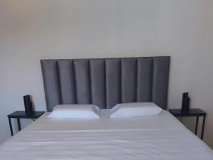 ein Bett mit einem schwarzen Kopfteil und zwei Kissen in der Unterkunft Kuća za odmor Silba in Silba