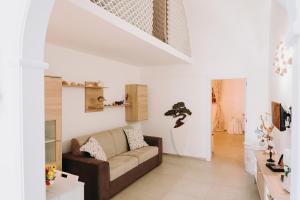 a living room with a brown couch and white walls at Mare Adesso in Polignano a Mare