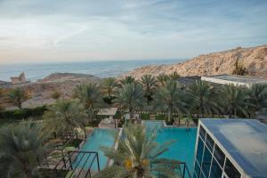 - une vue sur un complexe avec des palmiers et une piscine dans l'établissement Alberni Jabal Hafeet Hotel Al Ain, à Al-Aïn