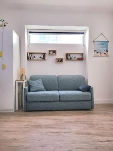 um sofá azul num quarto com uma janela em Chez Mélanie et Rodolphe em La Ciotat