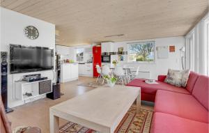 ein Wohnzimmer mit einem roten Sofa und einem Tisch in der Unterkunft 4 Bedroom Awesome Home In Odder in Odder