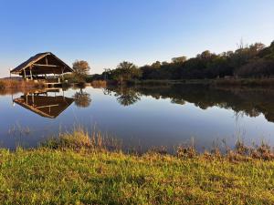 um grande lago com uma cabana no meio em Stone Meadows Country Estate-NV51 em Magaliesburg