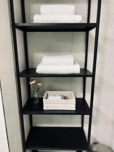 a black shelf with towels and a vase of flowers at CITY CENTRUM CHARMING apartment in Prague