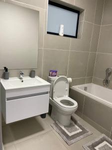 a bathroom with a toilet and a sink and a tub at 151 Ballito Luxury Villa in Ballito