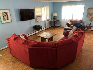 a living room with a red couch and a table at Beach Front on the Bay in our Rustic, Pet Friendly Cottage home in North Camellia Acres