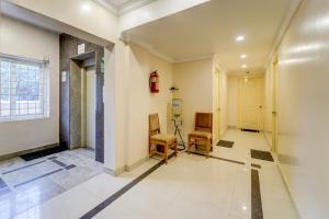 an empty hallway with two chairs and a window at G Silver Ashok Nagar in Chennai