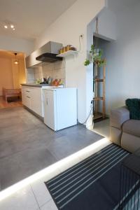 a living room with a white kitchen and a couch at Apartment Green in Poreč